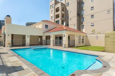 a swimming pool in the courtyard of a building at Elegant Apartment with Pool and Balcony Views in Cape Town