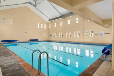 a large swimming pool in a large room at Elegant Apartment with Pool and Balcony Views in Cape Town