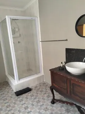 a bathroom with a sink and a glass shower at Impletio in Gordonʼs Bay