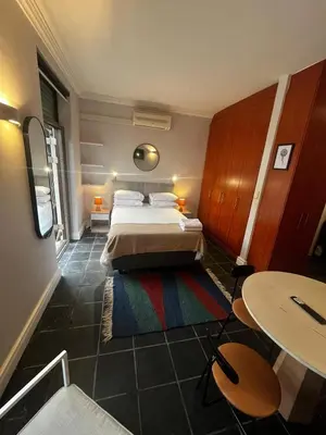 a bedroom with a bed and a table and a table at Live Like a Local in Stellies - By ARPA Hospitalities in Stellenbosch