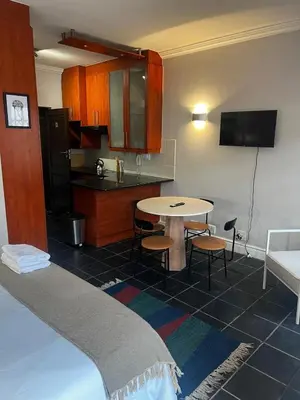 a room with a kitchen and a table and a bed at Live Like a Local in Stellies - By ARPA Hospitalities in Stellenbosch