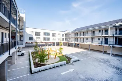 an apartment complex with a courtyard with a parking lot at Paarl 137 - Superior Studio Apartment with AC and Parking in Paarl