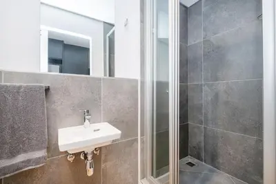 a bathroom with a sink and a shower at Paarl 137 - Superior Studio Apartment with AC and Parking in Paarl
