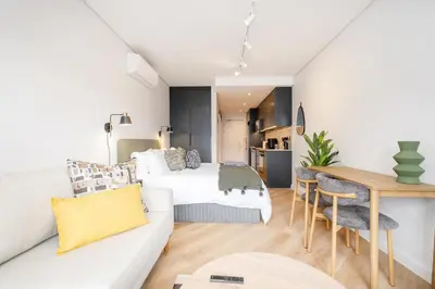 a living room with a bed and a dining room at Paarl Studio 138 - Ultra Modern Apartment with AC and onsite Parking in Paarl
