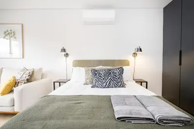 a bedroom with a bed and a couch at Paarl Studio 138 - Ultra Modern Apartment with AC and onsite Parking in Paarl