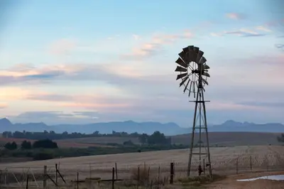 a windmill sitting in the middle of a field at Blouporselein guestfarm cabin in Hermon