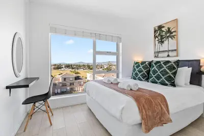 a bedroom with a large bed and a large window at Ocean View B503 in Cape Town