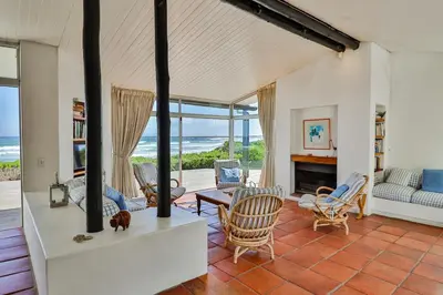 a living room with a view of the ocean at Turtle Drum ON THE BEACH in Bettyʼs Bay