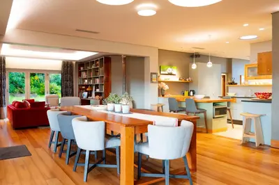 a kitchen and living room with a wooden table and chairs at Stellenbosch Farm Stay with Mountain Views & Pool in Stellenbosch