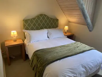 a bedroom with a bed with two lamps on two tables at Amatoni 44 in Stellenbosch