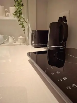 a black coffee maker sitting on top of a kitchen counter at The Harfield Hideaway in Cape Town