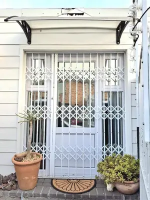 a gate on a house with potted plants at The Harfield Hideaway in Cape Town