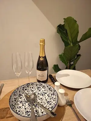 a bottle of wine sitting on a table with glasses at The Harfield Hideaway in Cape Town