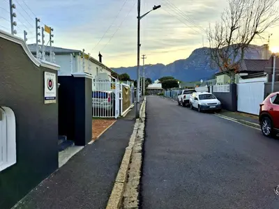 a street with cars parked on the side of the road at The Harfield Hideaway in Cape Town