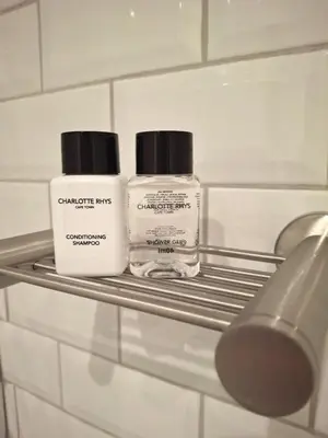 two bottles ofodorizers sitting on a shelf in a bathroom at The Harfield Hideaway in Cape Town