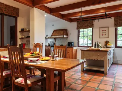 a kitchen with a wooden table with a bowl of fruit on it at The Neighbours Farm - Homestead in Stellenbosch