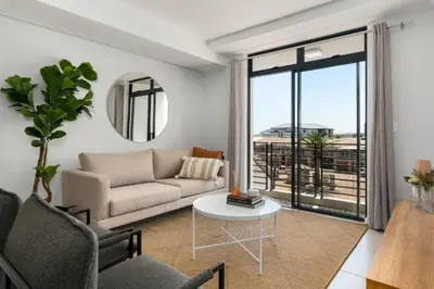 a living room with a couch and a table at Beautiful Beach Break! in Cape Town