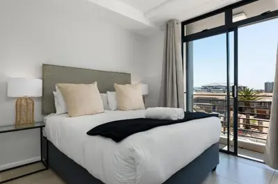 a bedroom with a large bed with a large window at Beautiful Beach Break! in Cape Town