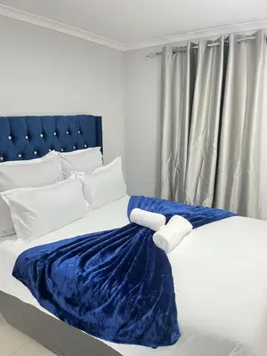 a bedroom with a bed with a blue blanket on it at The Perfect Place in Parow