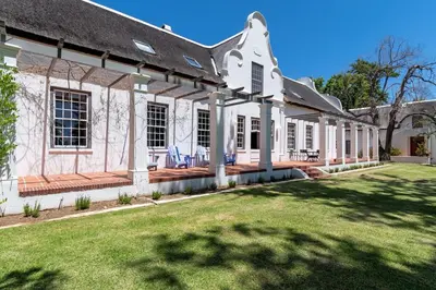 a large white house with a large yard at The Manor at Mont Angelis Estate in Stellenbosch