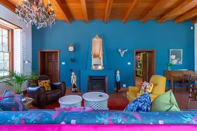 a living room with a couch and a blue wall at The Manor at Mont Angelis Estate in Stellenbosch