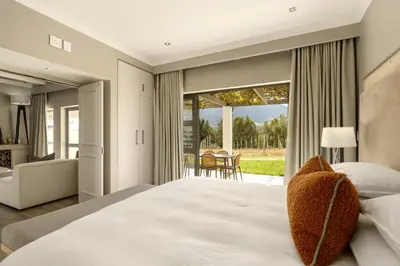 a bedroom with a large bed and a large window at Jonker Estate - Serene stay on Helshoogte Pass in Stellenbosch
