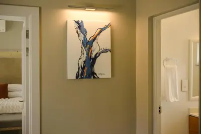a bathroom with a painting of a tree on the wall at Jonker Estate - Serene stay on Helshoogte Pass in Stellenbosch