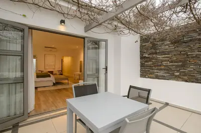 a dining room with a table and chairs and a bedroom at Jonker Estate - Serene stay on Helshoogte Pass in Stellenbosch