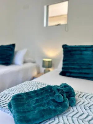 a green towel sitting on top of a bed at Ebb & Flow in Hermanus
