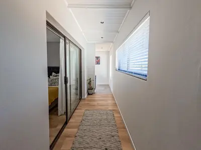 a hallway with a window and a rug on a wall at Imoyo Ocean Retreat in Hermanus