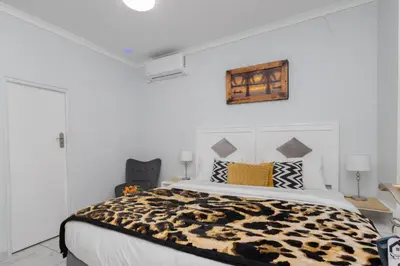 a bedroom with a bed with a leopard print blanket at Serena Inn Room 8 in Cape Town