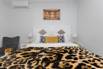 a bedroom with a bed with a leopard print blanket at Serena Inn Room 8 in Cape Town