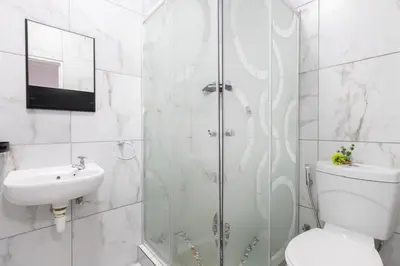 a bathroom with a shower and a toilet and a sink at Serena Inn Room 8 in Cape Town