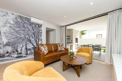 a living room with a couch and chairs and a table at Aan de Meul Luxury Apartments in Stellenbosch