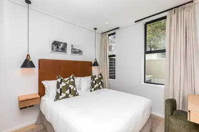 a bedroom with a bed and a window at Aan de Meul Luxury Apartments in Stellenbosch