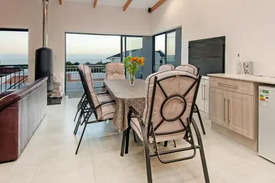 a kitchen and dining room with a table and chairs at Iets Nuuts in Hermanus