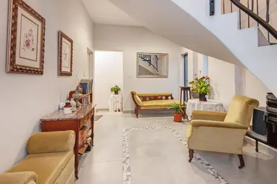 a living room with chairs and a table and a staircase at Iets Nuuts in Hermanus