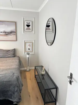 a bedroom with a bed and a mirror on the wall at Seabreeze Summit Retreat Your Perfect Escape in Cape Town