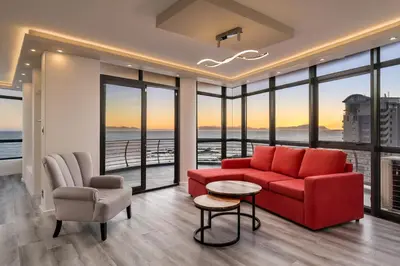 a living room with a red couch and a table and chairs at 903 Atlantica in Strand