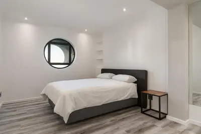 a white bedroom with a bed and a mirror at 903 Atlantica in Strand