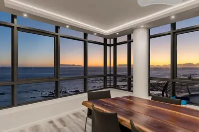 a dining room with a table and views of the ocean at 903 Atlantica in Strand