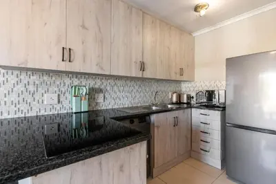 a kitchen with wooden cabinets and a stainless steel refrigerator at South Views 14 in Cape Town