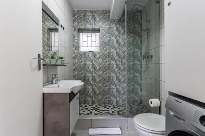 a bathroom with a shower and a sink and a toilet at Manhattan Square 17 in Cape Town