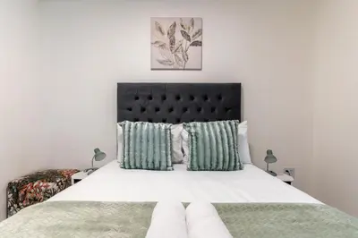 a bedroom with a large bed with a black headboard at Manhattan Square 17 in Cape Town