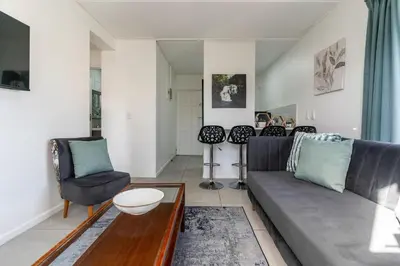 a living room with a couch and two chairs at Manhattan Square 17 in Cape Town