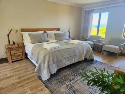 a bedroom with a large bed with two towels on it at Sea 'n Summit Hermanus in Hermanus
