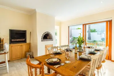 a dining room with a wooden table and chairs at Sea 'n Summit Hermanus in Hermanus