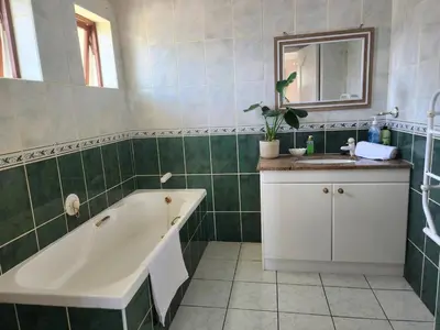 a bathroom with a tub and a sink and a mirror at Sea 'n Summit Hermanus in Hermanus