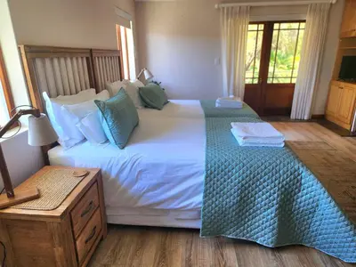 a bedroom with a large white bed with a green blanket at Sea 'n Summit Hermanus in Hermanus