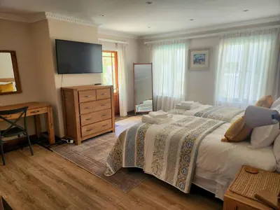 a bedroom with a bed and a dresser and a television at Sea 'n Summit Hermanus in Hermanus